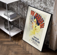 Woman dancing pouring wine poster in a black frame leaning beside a shelf in a raw-plaster loft