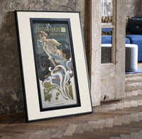 Woman blowing soap bubbles print in a black frame leaning beside a vintage door on parquet
