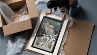 Woman blowing soap bubbles framed print being unpacked from protective bubble wrap and a box