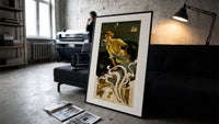 Two women blowing soap bubbles print in a slim black frame leaning on a dark sofa in a concrete print studio