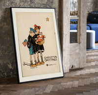Two children holding Santa doll print in a black frame leaning beside a vintage door on parquet