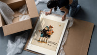 Two children holding Santa doll framed print being unpacked from protective bubble wrap and a box