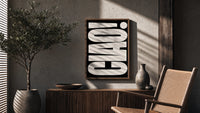 Ciao White on Black poster framed above a fluted sideboard beside a potted tree