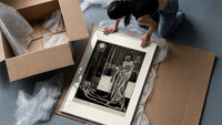 Cloaked skeletal masque figure standing framed print being unpacked from protective bubble wrap and a box