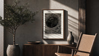 Boat caught in whirlpool vortex poster framed above a fluted sideboard beside an olive tree