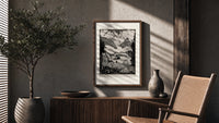 Mountain valley landscape with figure poster framed above a fluted sideboard beside an olive tree