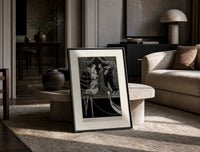 Elegant Venetian noblewoman with courtiers print in a black frame leaning on a travertine table in a sunlit lounge