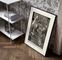 Ornate woman with flitting faces poster in a black frame leaning beside a shelf in a raw-plaster loft