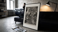 Ornate woman with flitting faces print in a slim black frame leaning on a dark sofa in a concrete print studio