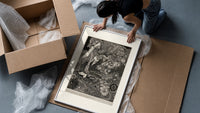 Ornate woman with flitting faces framed print being unpacked from protective bubble wrap and a box
