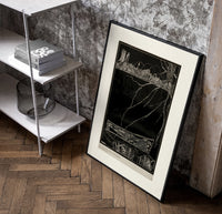 Buried man in coffin underground poster in a black frame leaning beside a shelf in a raw-plaster loft