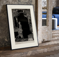 Man walking with torch in dark hall print in a black frame leaning beside a vintage door on parquet