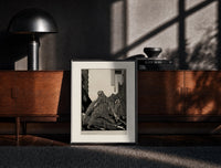 Black-framed Snarling ape attacking woman print on a moody console with designer coffee-table books