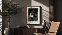 Gaunt sinister man over hidden figure poster framed above a fluted sideboard beside an olive tree