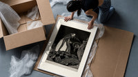 Gaunt sinister man over hidden figure framed print being unpacked from protective bubble wrap and a box