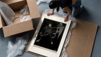 Two men in a sword duel framed print being unpacked from protective bubble wrap and a box
