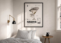 Classic Martini Cocktail Market print in a black frame above a bed with striped linens, a brass wall lamp and a sunlit window