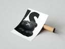 Close-up of KAWS figure with X-marked eye resting against bold typography on white, rolled poster