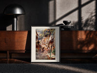 Black-framed Cobbled village street with boy and donkey print on a moody console with designer coffee-table books