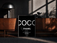 Black-framed Elegant woman with handbags fashion illustration print on a moody console with designer coffee-table books