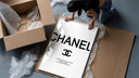 Chanel logo with quote framed print being unpacked from protective bubble wrap and a box