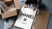 Chanel logo with quote framed print being unpacked from protective bubble wrap and a box
