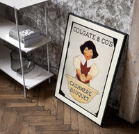 Smiling person washing hands in basin poster in a black frame leaning beside a shelf in a raw-plaster loft