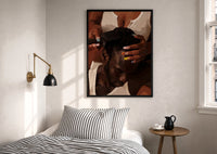 Combing Hair with Painted Nails print in a black frame above a bed with striped linens, a brass wall lamp and a sunlit window