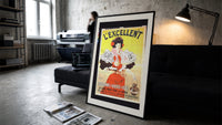 Woman serving consomme with tray print in a slim black frame leaning on a dark sofa in a concrete print studio