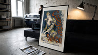 Woman washing hands in basin print in a slim black frame leaning on a dark sofa in a concrete print studio