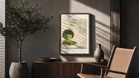 Green perfume bottle on box poster framed above a fluted sideboard beside an olive tree