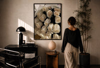 Cream Rose Bouquet print in a black frame on a sunlit plaster wall, a woman looking on beside a mushroom lamp