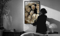 Cream Rose Bouquet print in a slim black frame being hung on a sunlit wall in a monochrome room