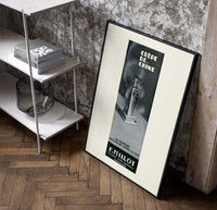 Perfume bottle on pedestal poster in a black frame leaning beside a shelf in a raw-plaster loft