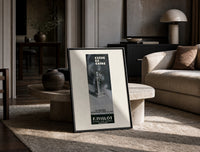 Perfume bottle on pedestal print in a black frame leaning on a travertine table in a sunlit lounge