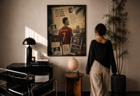 Cristiano Ronaldo print in a black frame on a sunlit plaster wall, a woman looking on beside a mushroom lamp