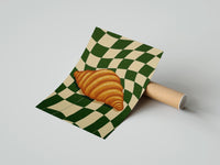 Gently curled Croissant on Green Checkerboard print beside its protective shipping tube