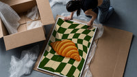 Croissant on Green Checkerboard framed print being unpacked from protective bubble wrap and a box