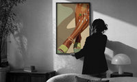 Pale Green Platform Sandals print in a slim black frame being hung on a sunlit wall in a monochrome room