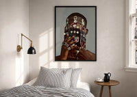 Dangling Jewelry Over the Face print in a black frame above a bed with striped linens, a brass wall lamp and a sunlit window