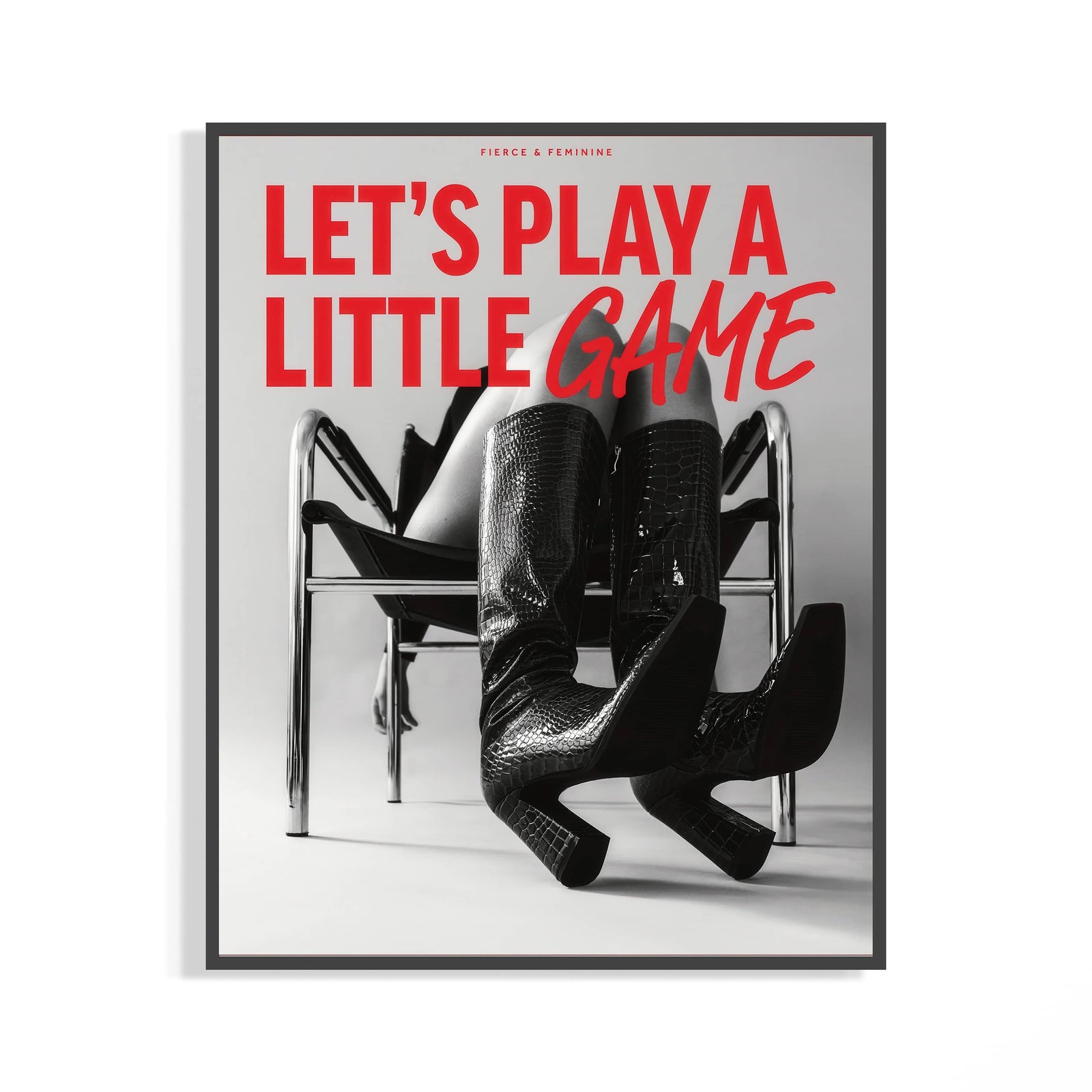 Dark-framed fashion poster on white wall with red text over B&W woman in black croc thigh-high boots on a chrome chair