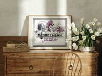Woman smelling lilac flowers print in an oak frame on a farmhouse dresser beside white tulips