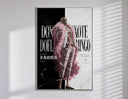 blond man in pink feather coat poster in a slim frame on a bright wall with soft window light