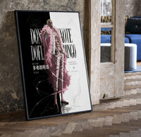 blond man in pink feather coat print in a black frame leaning beside a vintage door on parquet