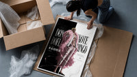 blond man in pink feather coat framed print being unpacked from protective bubble wrap and a box