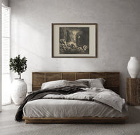 Radiant angel guiding two figures print in a dark wood frame above a rattan bed on a plaster wall