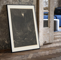 Man facing lion in dark forest print in a black frame leaning beside a vintage door on parquet