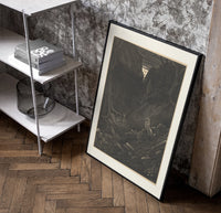 Man facing lion in dark forest poster in a black frame leaning beside a shelf in a raw-plaster loft