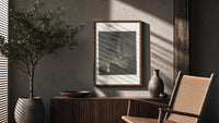 Two robed figures on cliff ledge poster framed above a fluted sideboard beside an olive tree