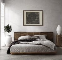 Winged demon Lucifer in underworld cavern print in a dark wood frame above a rattan bed on a plaster wall